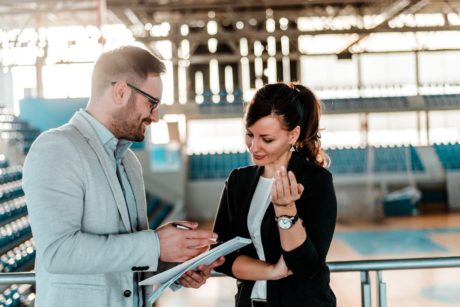 a man and a woman in a stadium, involved in coaching and communication activities