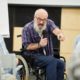 man in wheelchair presenting to a crowd