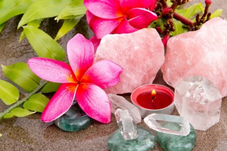 a serene beach scene featuring roses, crystals, and a candle, symbolizing the calming essence of introduction to crystal healing