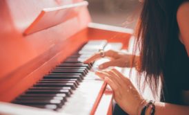 a woman skillfully playing the piano, piano course online for aspiring musicians