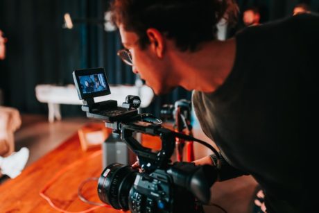 a man recording a video in a studio, focusing on video and photography