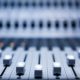 close-up of a mixing board with numerous knobs, used for composing ambient music in a creative studio setting