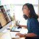 A woman at a desk, working on a computer and keyboard to create a WordPress website