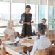 A woman confidently presents to a group, showcasing her leadership skills mastery