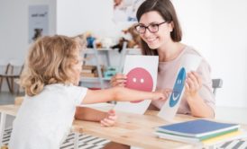 child showing drawing to school teacher