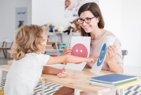 child showing drawing to school teacher