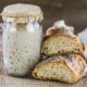 a sourdough bread alongside a jar of sourdough, showcasing the art of sourdough baking class