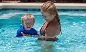 mom teaching toddler how to swim