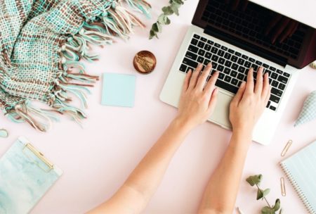 blogger typing on macbook