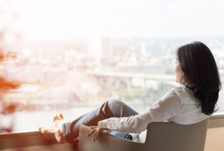 woman relaxing on lounge chair looking at view of the city