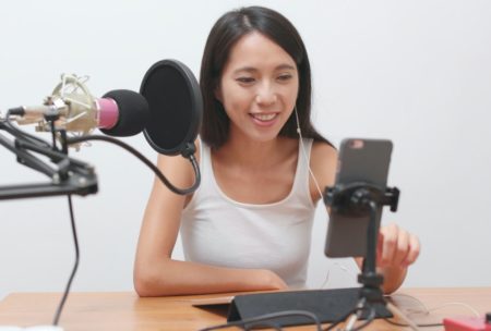 woman in white top streaming a webcast webinar