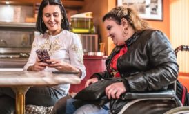 woman showing website to a handicapped person