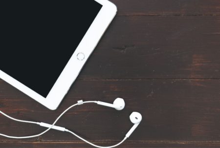 tablet and earphones on wooden table, used for iPad music production