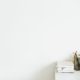 white desk with a notebook against a white wall