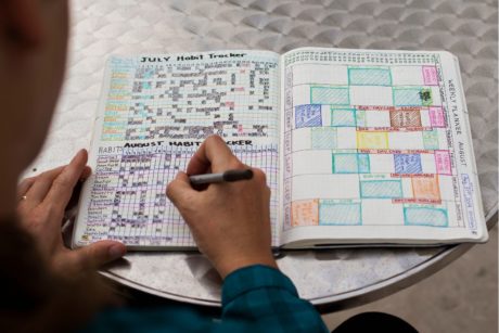 woman writing on a bullet journal