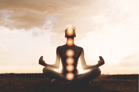 man with aligned chakras sitting and meditating