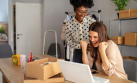 two happy women working on office desk