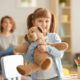 girl smiling and hugging a teddy bear