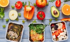 trays of healthy food arranged on top of gray wooden table