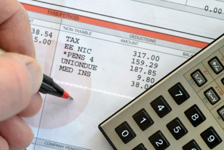 man budgeting using a balance sheet and calculator