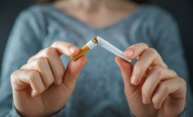 woman breaking a cigarette in two with her hands