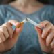 woman breaking a cigarette in two with her hands