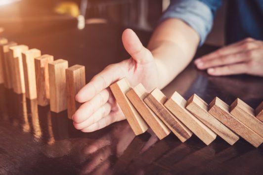 agile manager stopping a pile of wooden blocks from falling