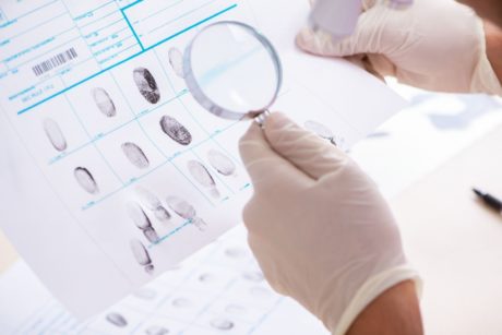 criminologist examining fingerprint profile