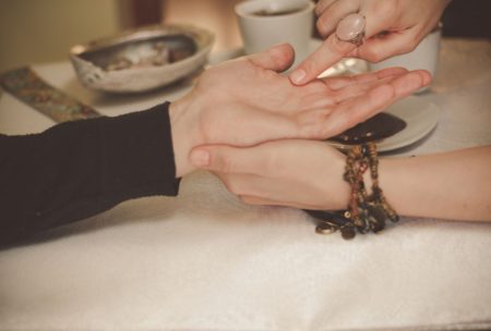 palm reader pointing at a person's palm