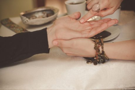 palm reader pointing at a person's palm