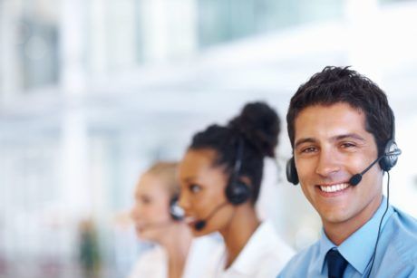 a man with a headset, smiling in an office setting, symbolizing customer service excellence