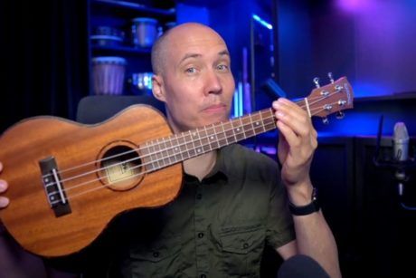 a man holding a ukulele demonstrating learn how to play ukulele