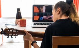 woman taking online courses about harmony and theory for guitar