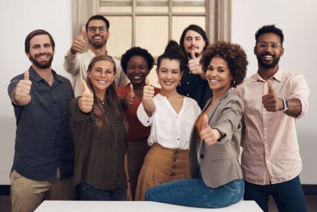 People from different backgrounds showing thumbs up, symbolizing relentless optimism.