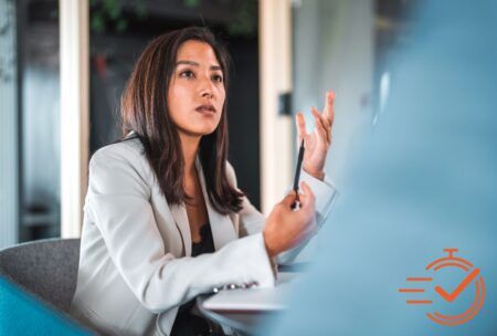 A woman in a business suit giving advice on how to be more assertive.