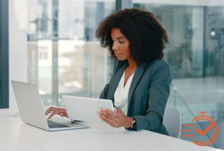 Businesswoman at table with laptop, improving productivity.