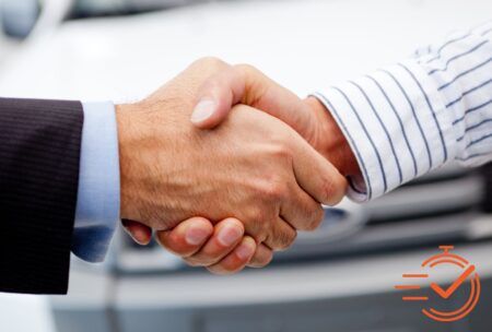 handshake between two people in front of a car, representing the secrets of closing the sale