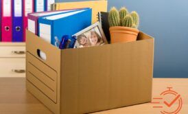 A desk showcases a box of books and pens, reflecting the process of coping with redundancy and seeking new opportunities.