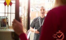 A man and woman smiling in front of a door, ready for their door-to-door sales pitch.