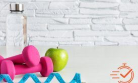 A bottle of water, a dumbbell, and an apple, showcasing key elements of health and wellness for a fit lifestyle.