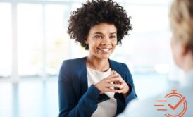 A woman in a business suit engages in conversation, showcasing her excellent listening skills with another woman.