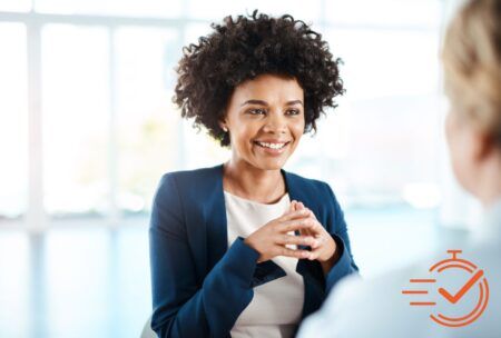 A woman in a business suit engages in conversation, showcasing her excellent listening skills with another woman.