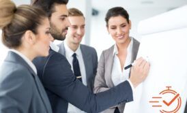 business professionals in a positive training environment, attentively gathered around a whiteboard for a meeting