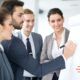 business professionals in a positive training environment, attentively gathered around a whiteboard for a meeting