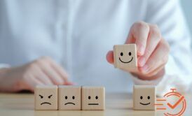 A person displays wooden blocks featuring smiley faces, highlighting a creative method for enhancing customer experience training