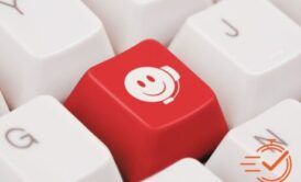 A red smiley face button on a white keyboard, highlighting a lighthearted touch in dealing with difficult customers training