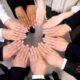 diverse business team forming a circle with hands together, representing engaging your people in the workplace