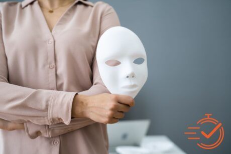 A woman holds a mask, symbolizing the importance of fraud awareness and recognizing deception