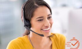 a cheerful woman with a headset uses her computer, demonstrating how to manage customer needs with ease