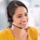 a cheerful woman with a headset uses her computer, demonstrating how to manage customer needs with ease